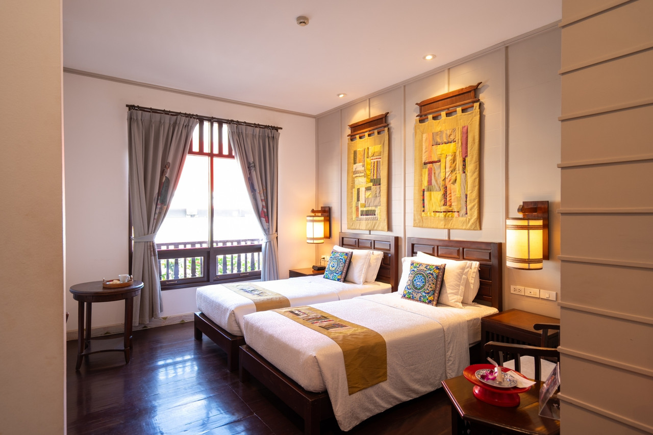 ห้องพักเตียงคู่ตกแต่งด้วยผ้าทอไทลื้อและเฟอร์นิเจอร์ไม้สัก Pukha Nanfa Hotel