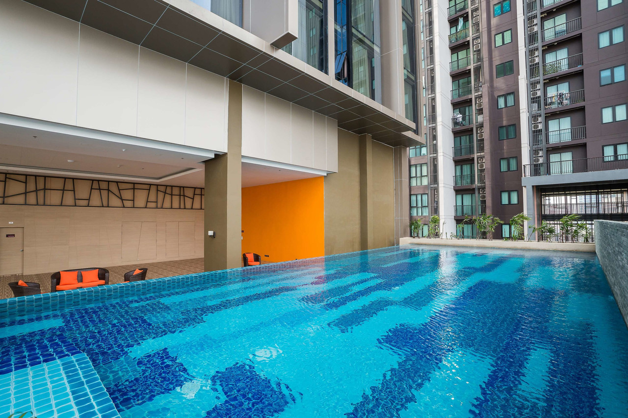 Outdoor swimming pool with orange-accent sun loungers
