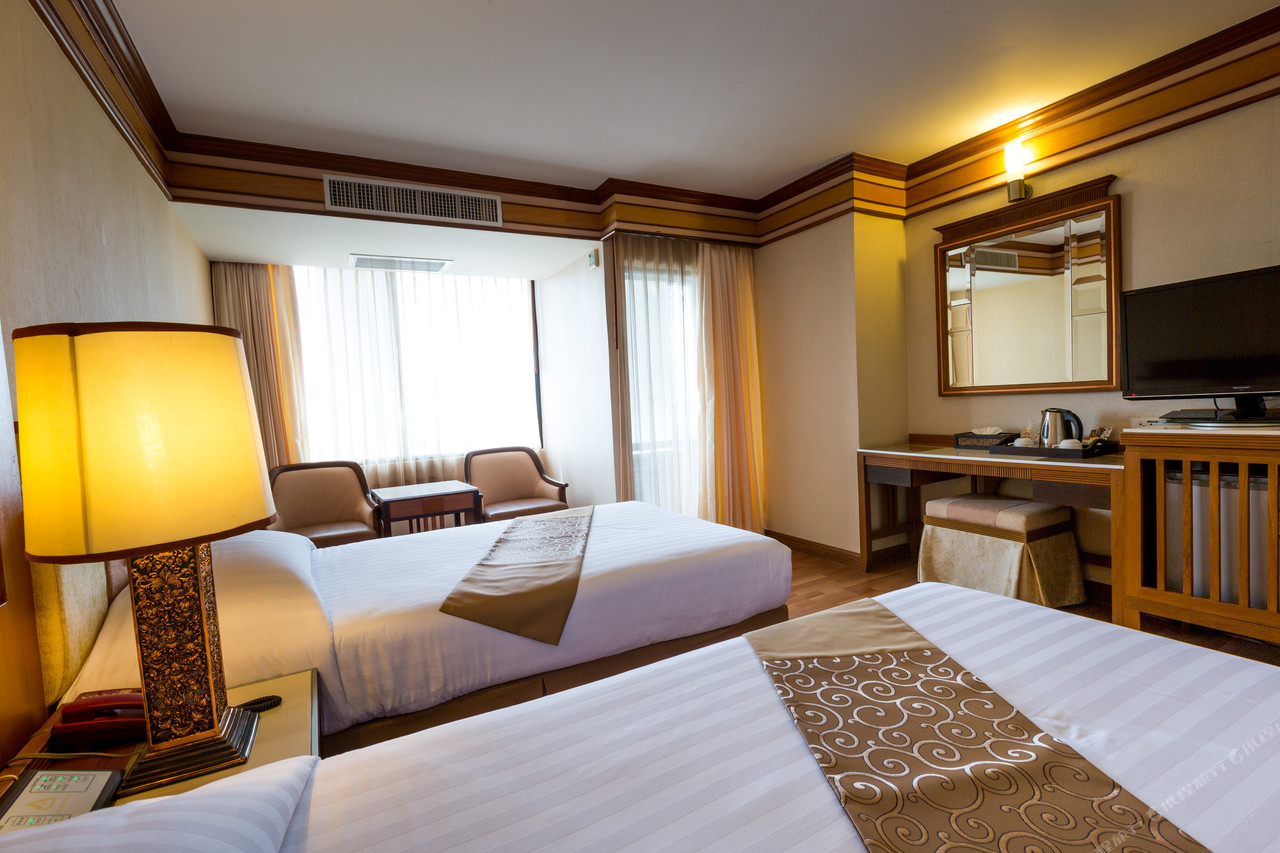 ห้องพักโทนไม้สักของ Asia Airport Hotel พร้อมเตียงคู่และโต๊ะเครื่องแป้ง