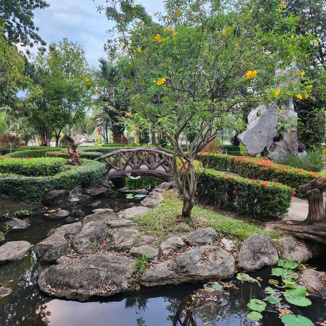 Landscaped rock garden with an arched bridge and pond at The Pine Resort