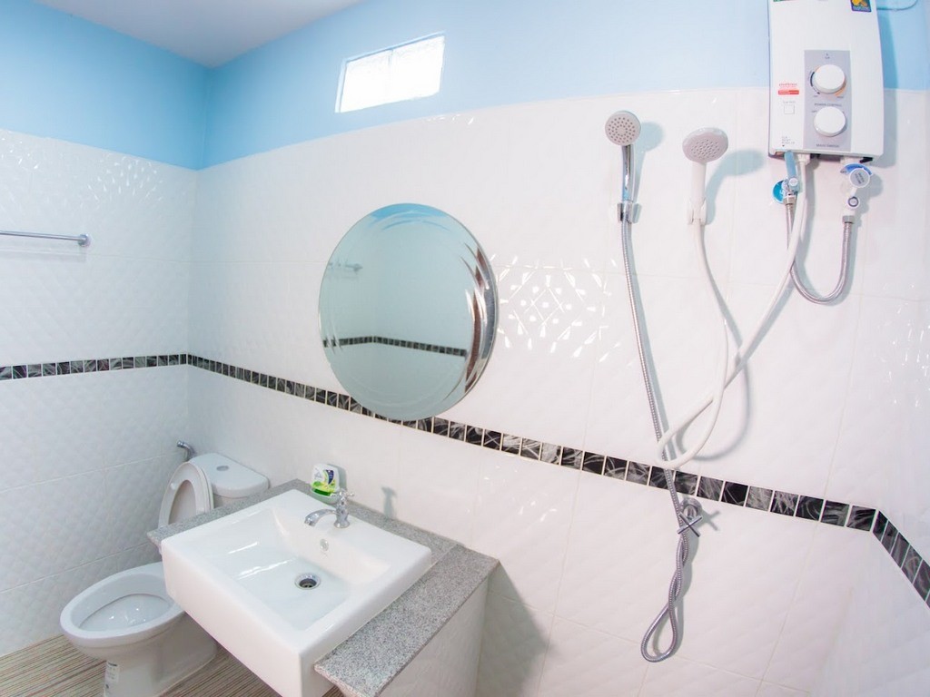 ห้องน้ำในตัวกระเบื้องขาว-ฟ้า มีเครื่องทำน้ำอุ่นและฝักบัว Chokphaiboon Apartment Pattani