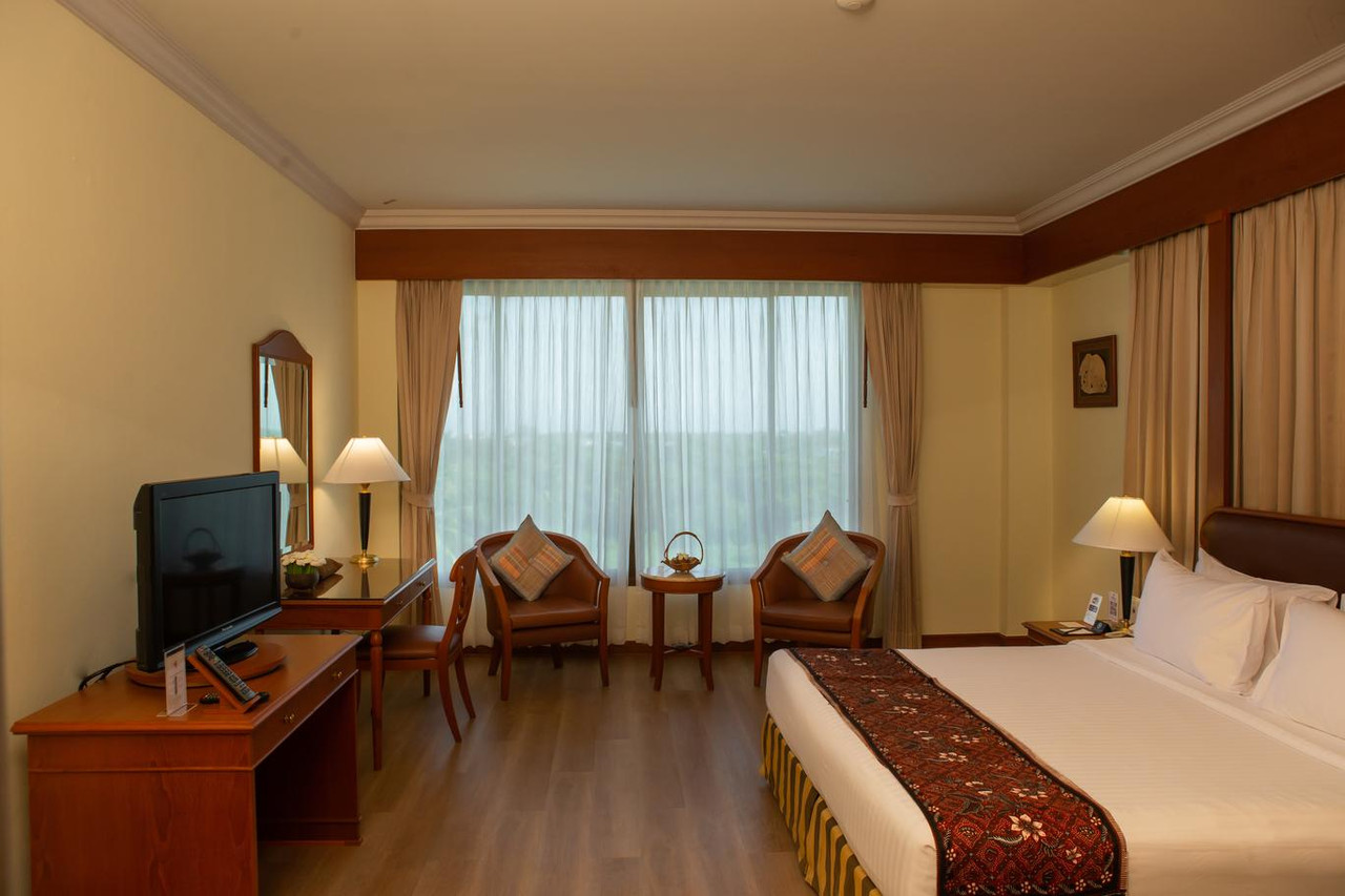 ห้องพัก CS Pattani Hotel พื้นไม้ โต๊ะทำงาน และมุมนั่งเล่นริมหน้าต่างบานใหญ่