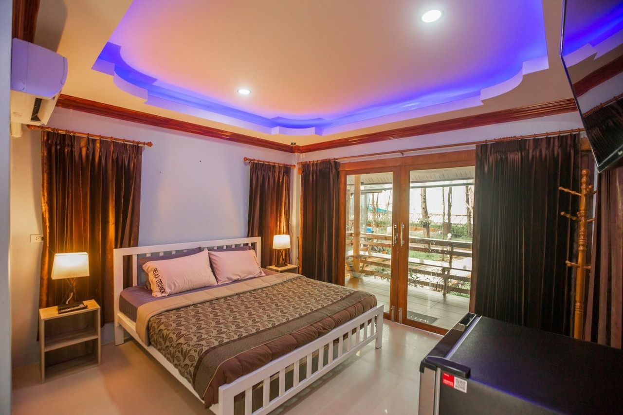 ห้องนอนพร้อมประตูบานเลื่อนออกระเบียงวิวสวนและทะเล