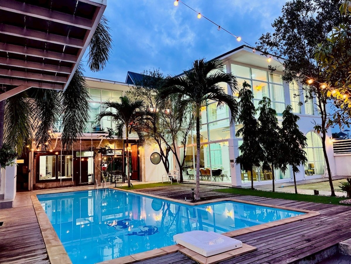 สระว่ายน้ำส่วนตัวและอาคารกระจกของ The Grand Pool Villa Pattani ยามเย็น