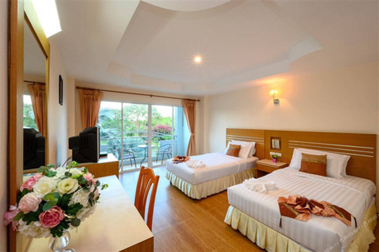 ห้องพักเตียงคู่ของ Chaikana Thani Hotel มีระเบียงและพื้นไม้