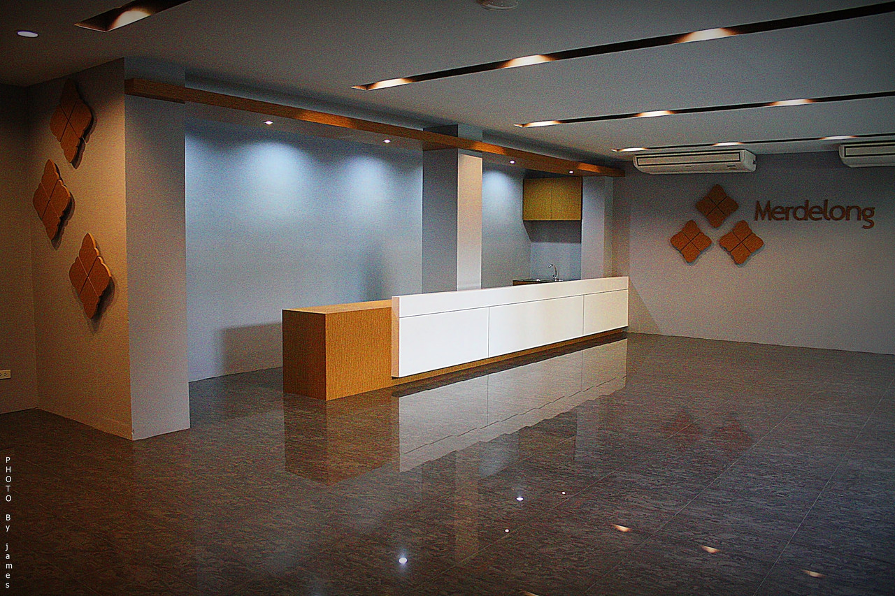 ล็อบบี้ Merdelong Hotel พร้อมเคาน์เตอร์ต้อนรับและผนังลายไม้