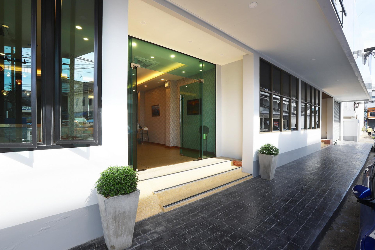 ทางเข้าและล็อบบี้กระจกของ Mest Hotel พัทลุง ริมถนนในเมือง