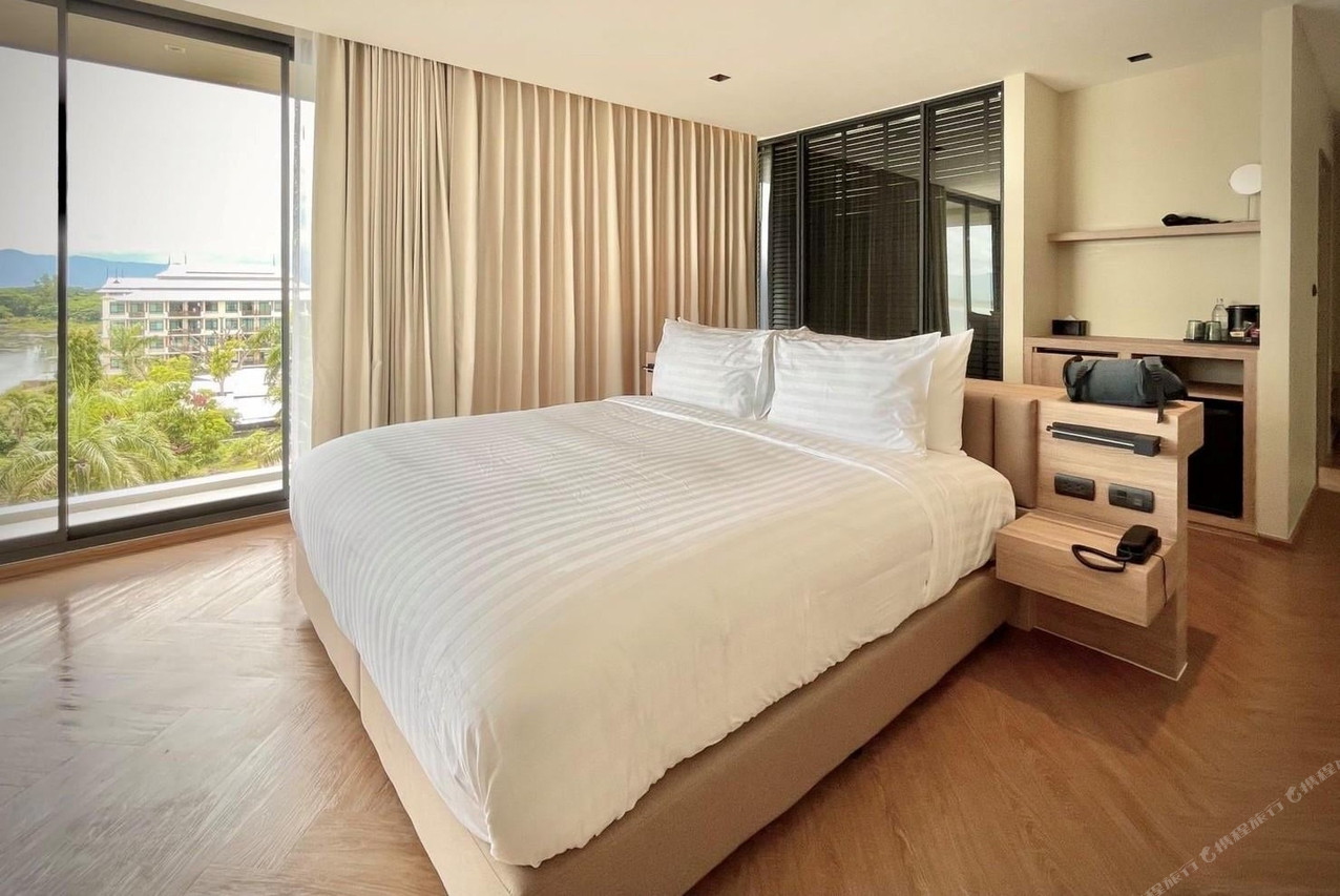 ห้องนอนเตียงใหญ่ M2 Hotel Waterside กระจกบานใหญ่เห็นกว๊านพะเยาและเทือกเขา