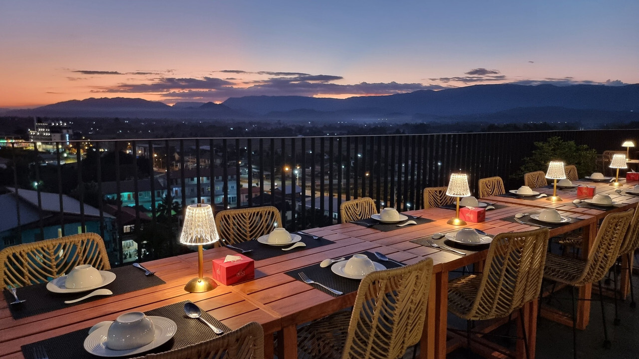 โต๊ะอาหารบนรูฟท็อป Livist Resort Phetchabun มองเห็นทิวเขาและไฟเมืองตอนพระอาทิตย์ตก
