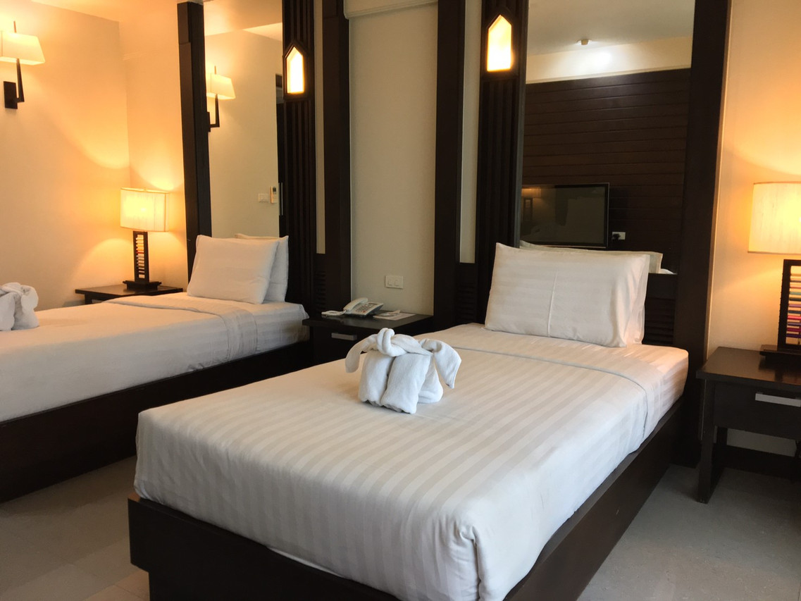 ห้องพักเตียงคู่ตกแต่งงานไม้สักสีเข้มและไฟหัวเตียงทรงจั่ว Huern Na Na Boutique Hotel