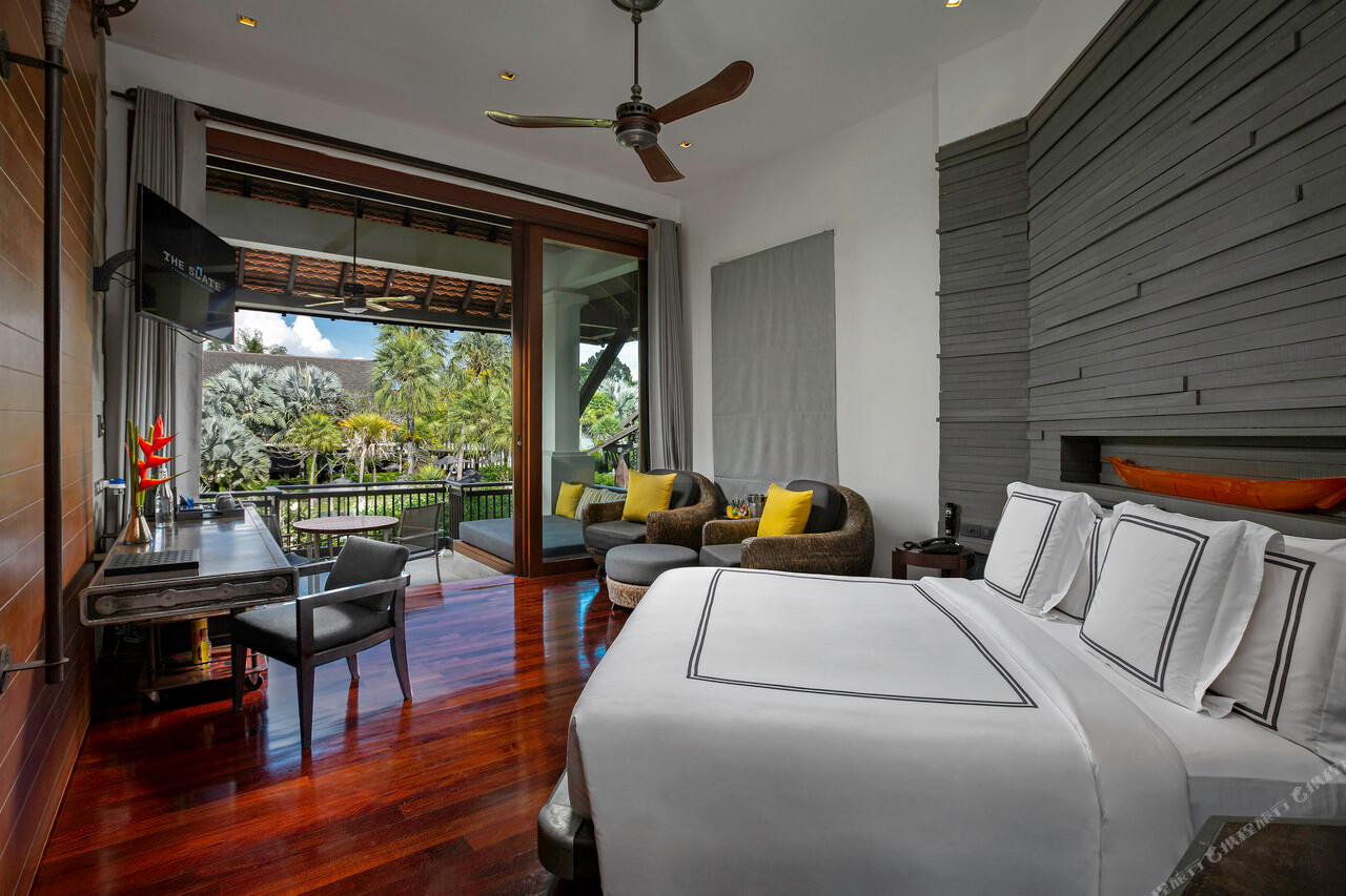 Industrial-chic guest room with red wood floors and a garden balcony