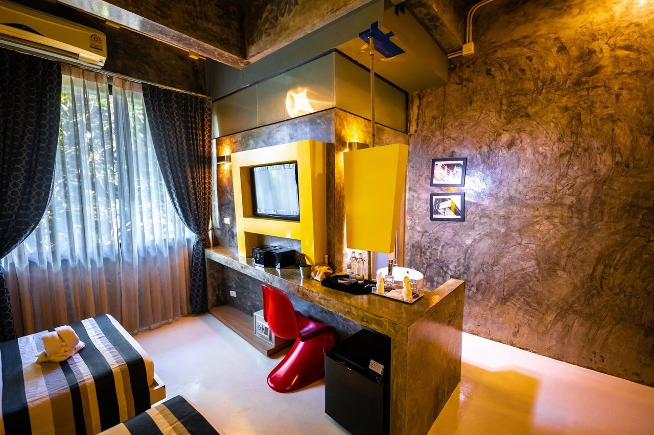 ห้องพักสไตล์ loft โต๊ะปูนขัดมัน เก้าอี้ Panton สีแดง ผนังปูนเปลือย