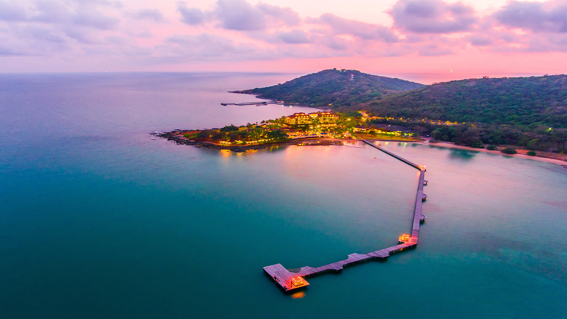 ภาพมุมสูงตอนพระอาทิตย์ตก เห็นท่าเรือส่วนตัวยื่นลงทะเลของ Rayong Resort Hotel