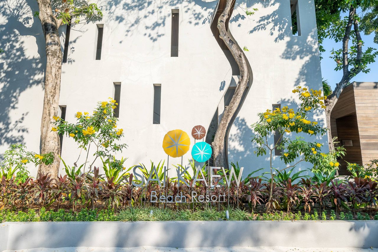 ป้ายทางเข้า Sai Kaew Beach Resort ท่ามกลางสวนดอกไม้