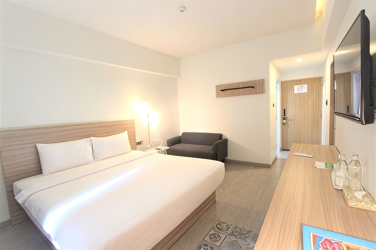 ห้องพักรีโนเวตใหม่ เตียงคิงไซส์ โทนไม้-ขาว มีน้ำดื่มฟรีบนโต๊ะ
