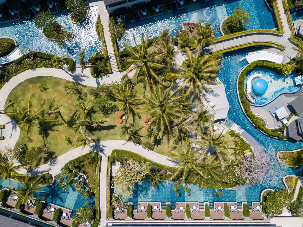Aerial view of the winding lagoon pool through palm gardens at Melia Koh Samui