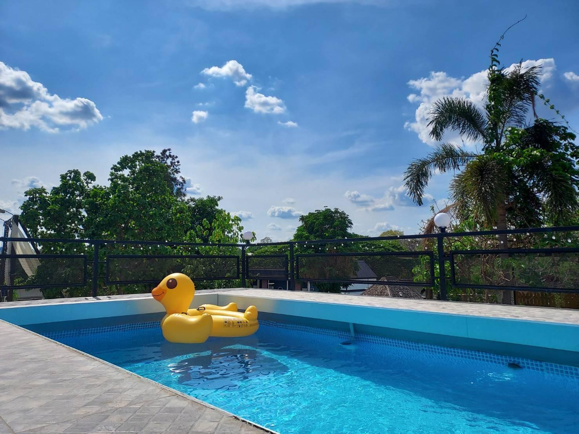 สระว่ายน้ำกลางแจ้งของ Maai Horm Boutique Resort ฉากหลังเป็นต้นไม้และท้องฟ้า