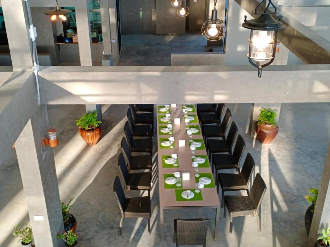Long communal dining table in the resort restaurant with an airy ceiling