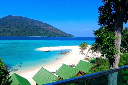 หาดทรายขาวและเรือหางยาวหน้า Mountain Resort Koh Lipe มองเห็นเกาะอาดัง