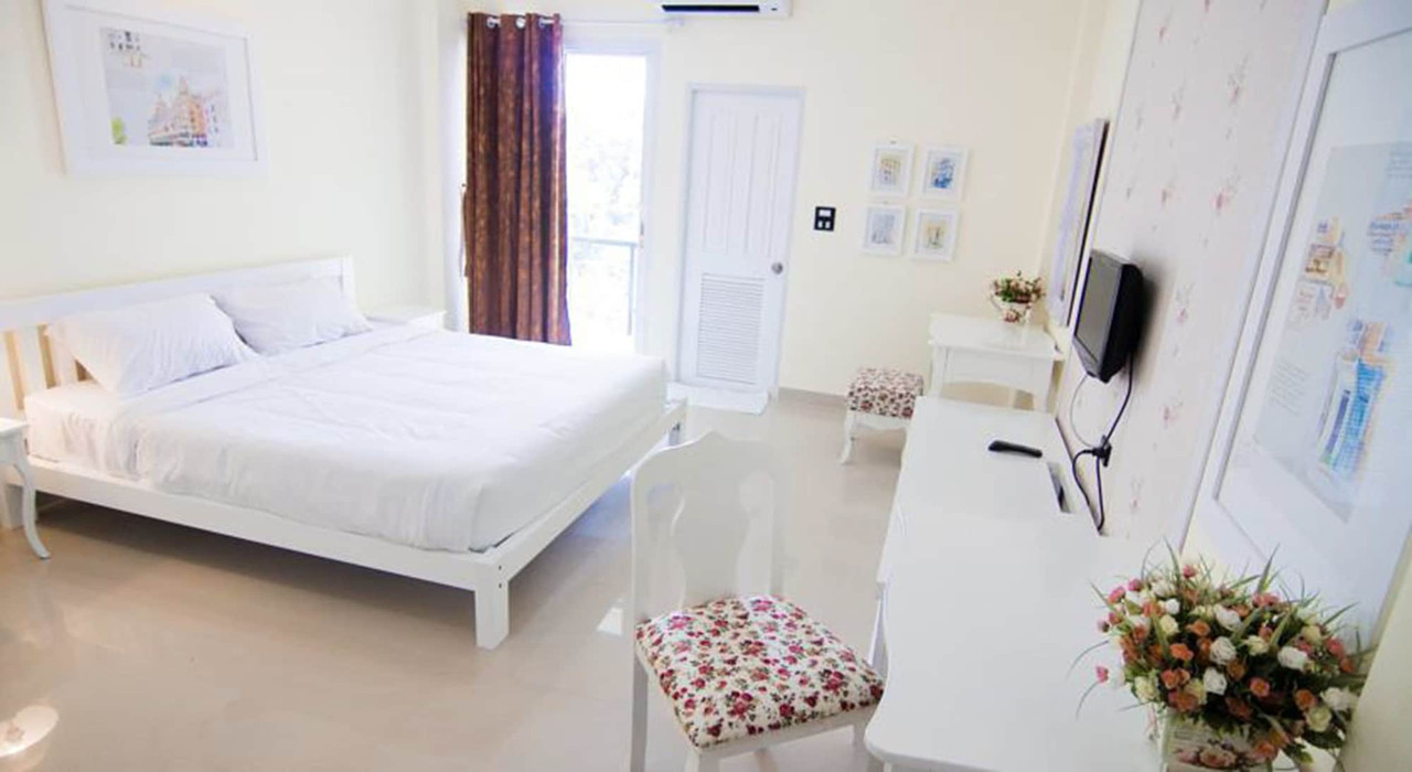 ห้องพักโทนขาวสว่าง เฟอร์นิเจอร์ไม้สีขาว มีระเบียงส่วนตัว Boonsiri Boutique Hotel