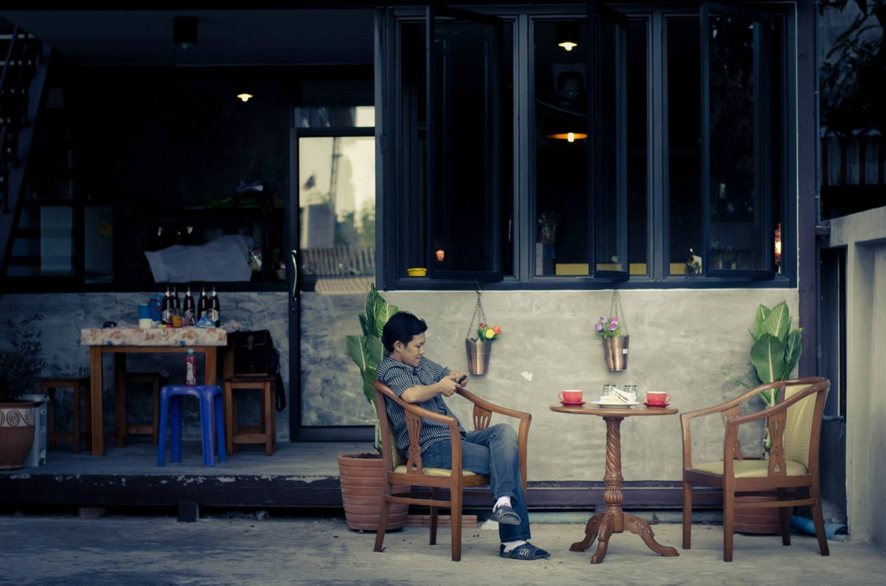 มุมร้านกาแฟกลางแจ้งหน้าโรงแรม โต๊ะไม้และที่นั่งชิลล์
