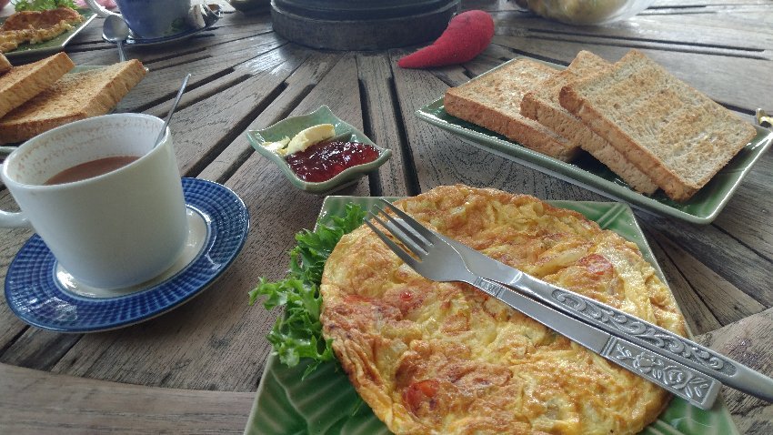 อาหารเช้าไข่เจียว ขนมปังปิ้ง และกาแฟสดบนโต๊ะไม้