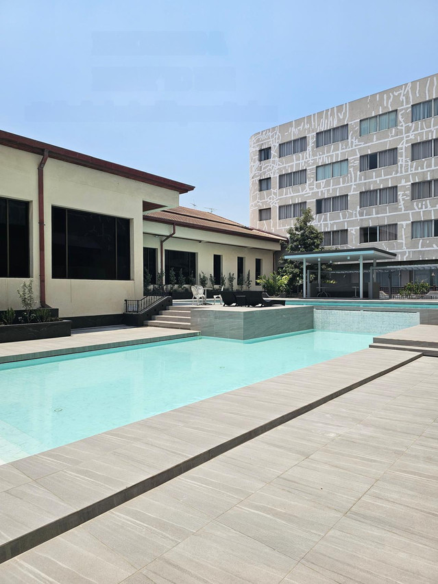 สระว่ายน้ำกลางแจ้งของ Songphanburi Hotel กับตึกพักด้านหลัง