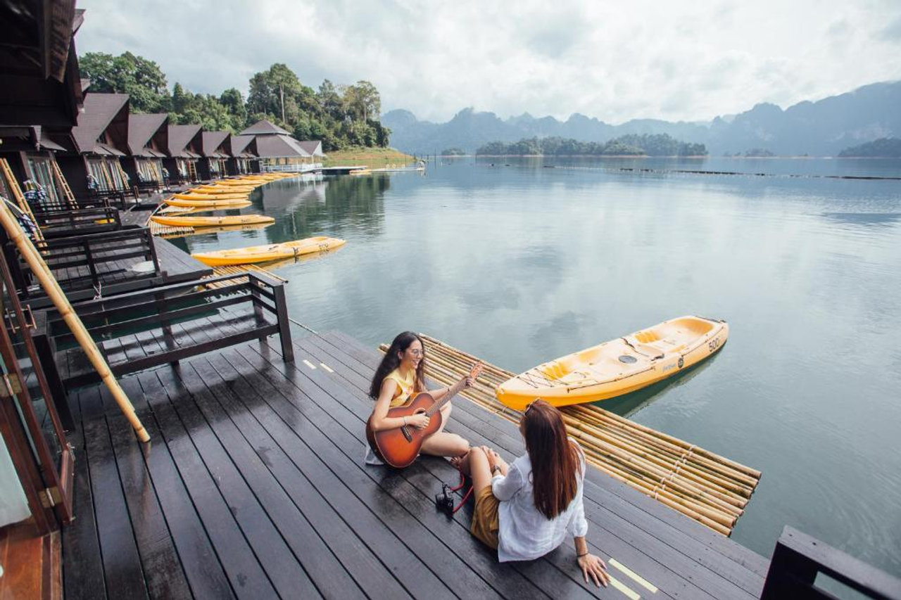 แถวห้องแพไม้ริมน้ำของ 500 Rai พร้อมเรือคายัคสีเหลืองจอดหน้าระเบียง