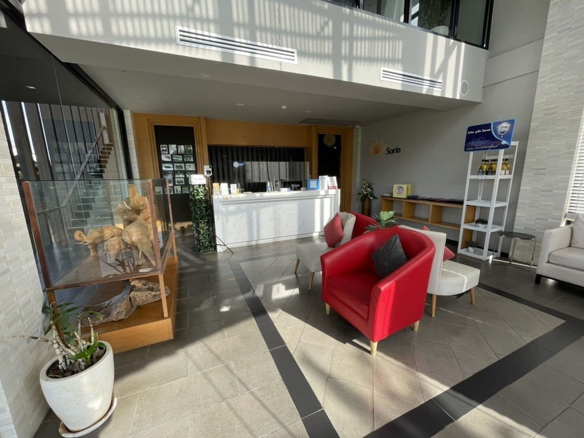 ล็อบบี้ Sorin Boutique Hotel เคาน์เตอร์ไม้ เก้าอี้แดง โซนนั่งเล่น