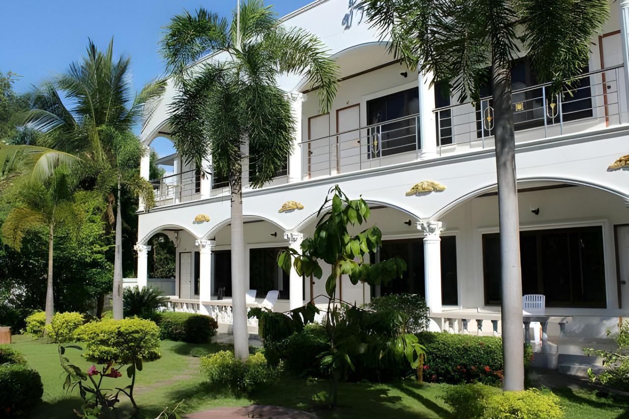 ด้านข้างตึกสีขาวซุ้มโค้ง ระเบียงชั้นบน ในสวนดอกไม้ White Elephant Resort สุรินทร์