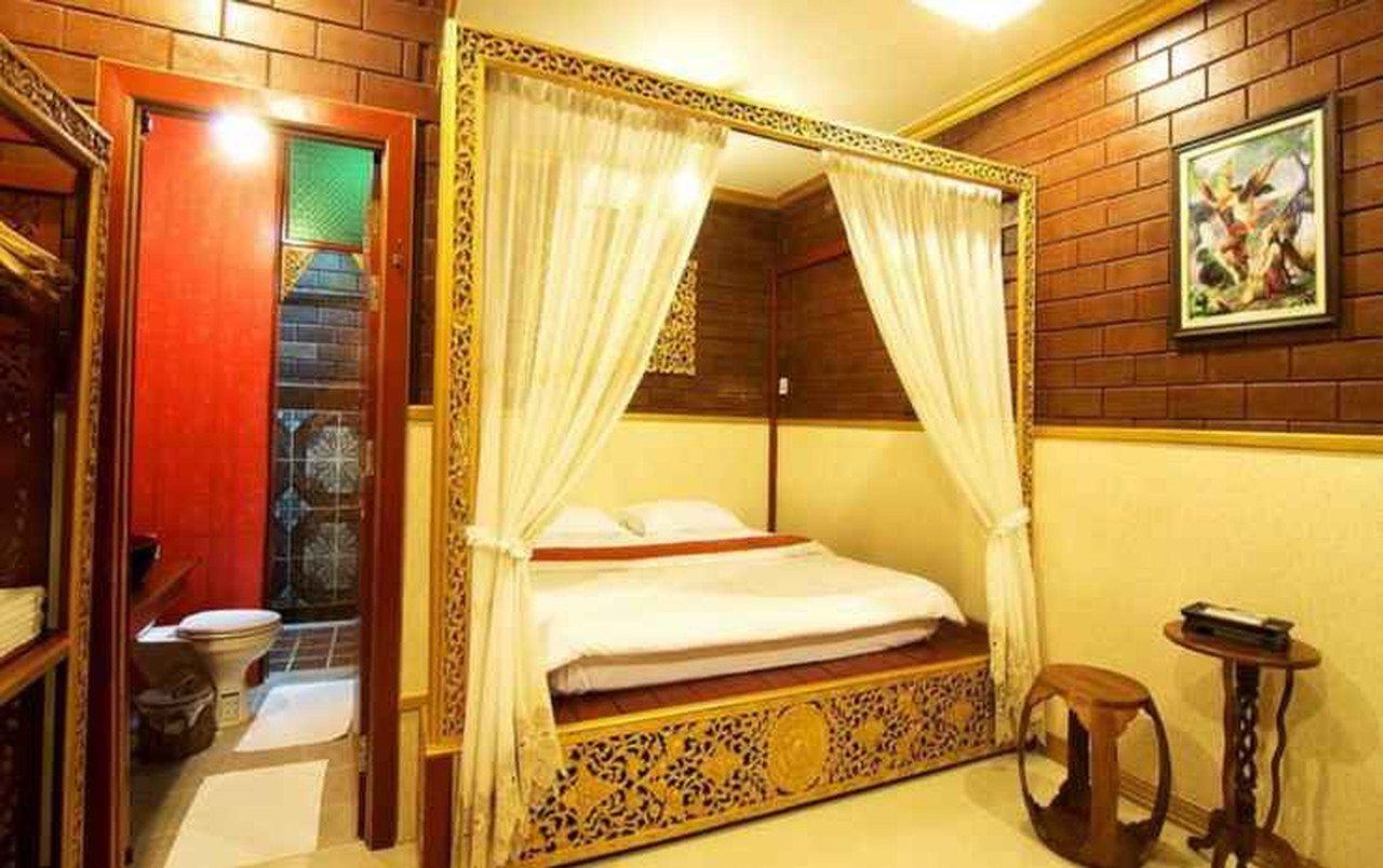 ห้องพัก Irawadee Resort เตียงสี่เสาผ้าม่านขาว ผนังอิฐและห้องน้ำในตัว