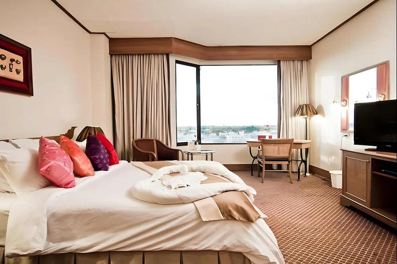 ห้อง Deluxe ของ Laithong Hotel ตกแต่งโทนอบอุ่น มีหน้าต่างมุมมองเมือง