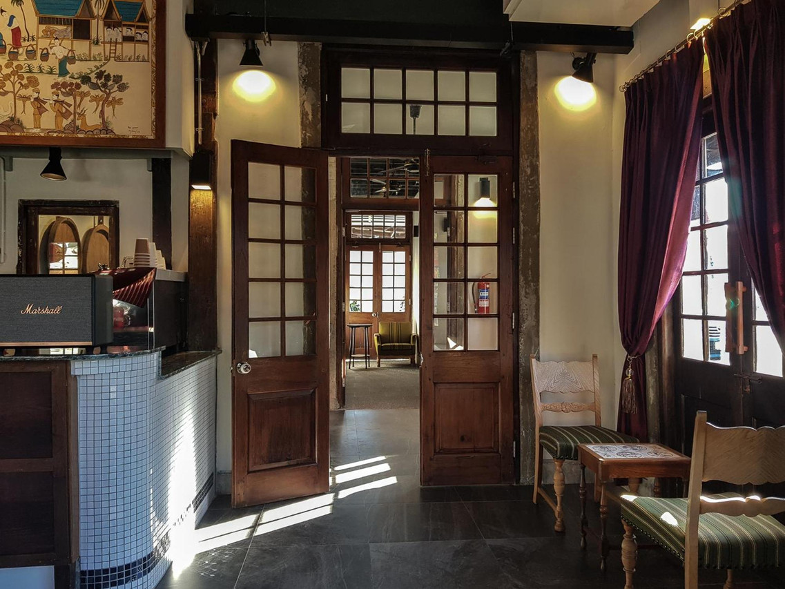 Cafe corner with restored timber doors, a vintage speaker and Isan folk art