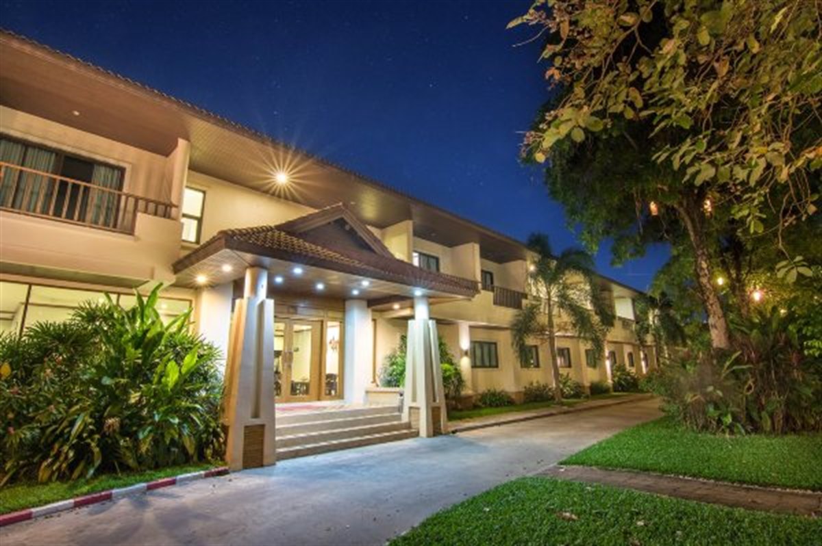 ทางเข้าหน้าโรงแรม Tara President Udon Thani ช่วงพลบค่ำ มีหลังคาทรงจั่วและไฟส่องเสา