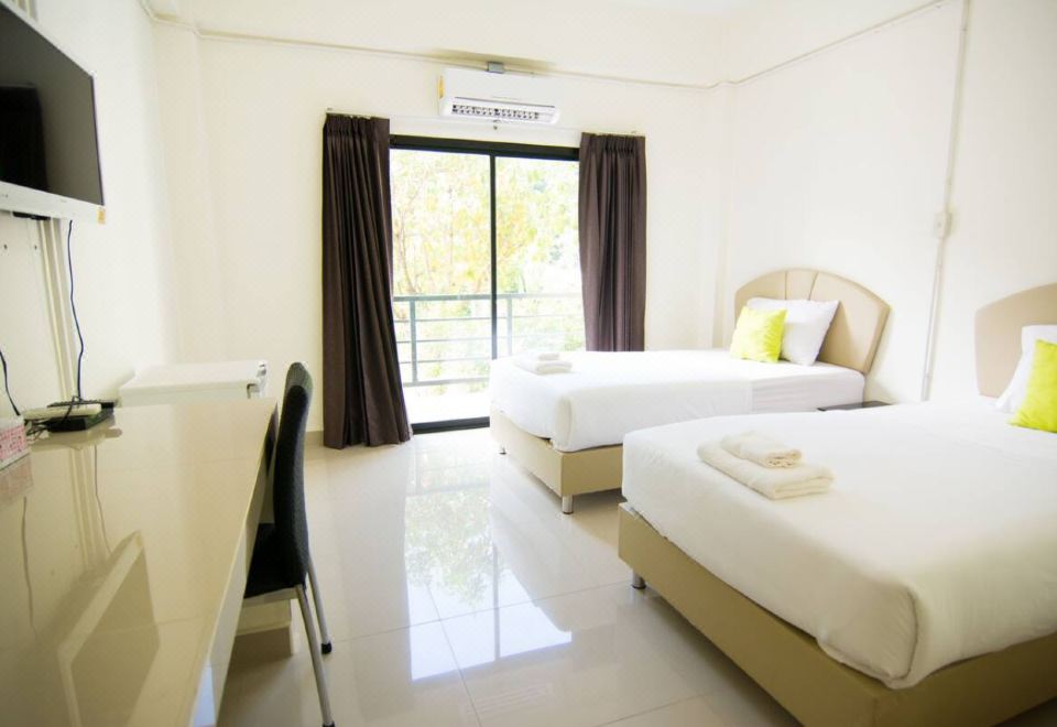 ห้องพักเตียงคู่ของ Sunee Boutique Hotel หมอนสีเขียวมะนาว พื้นกระเบื้องขาว ประตูกระจกออกระเบียง