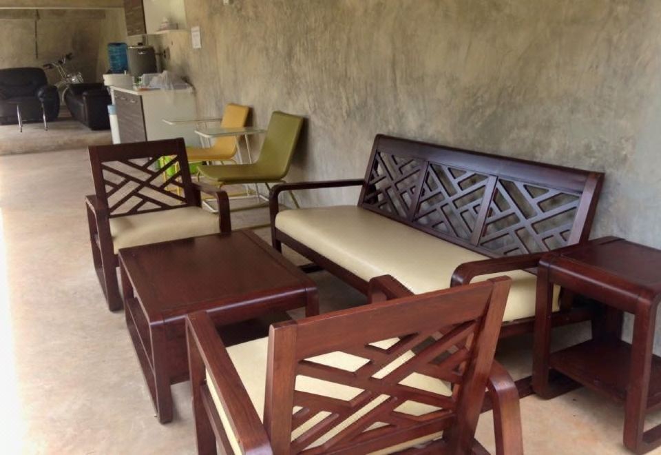 มุมนั่งเล่นเฟอร์นิเจอร์ไม้ ผนังปูนขัดมัน ของ Sunee Boutique Hotel