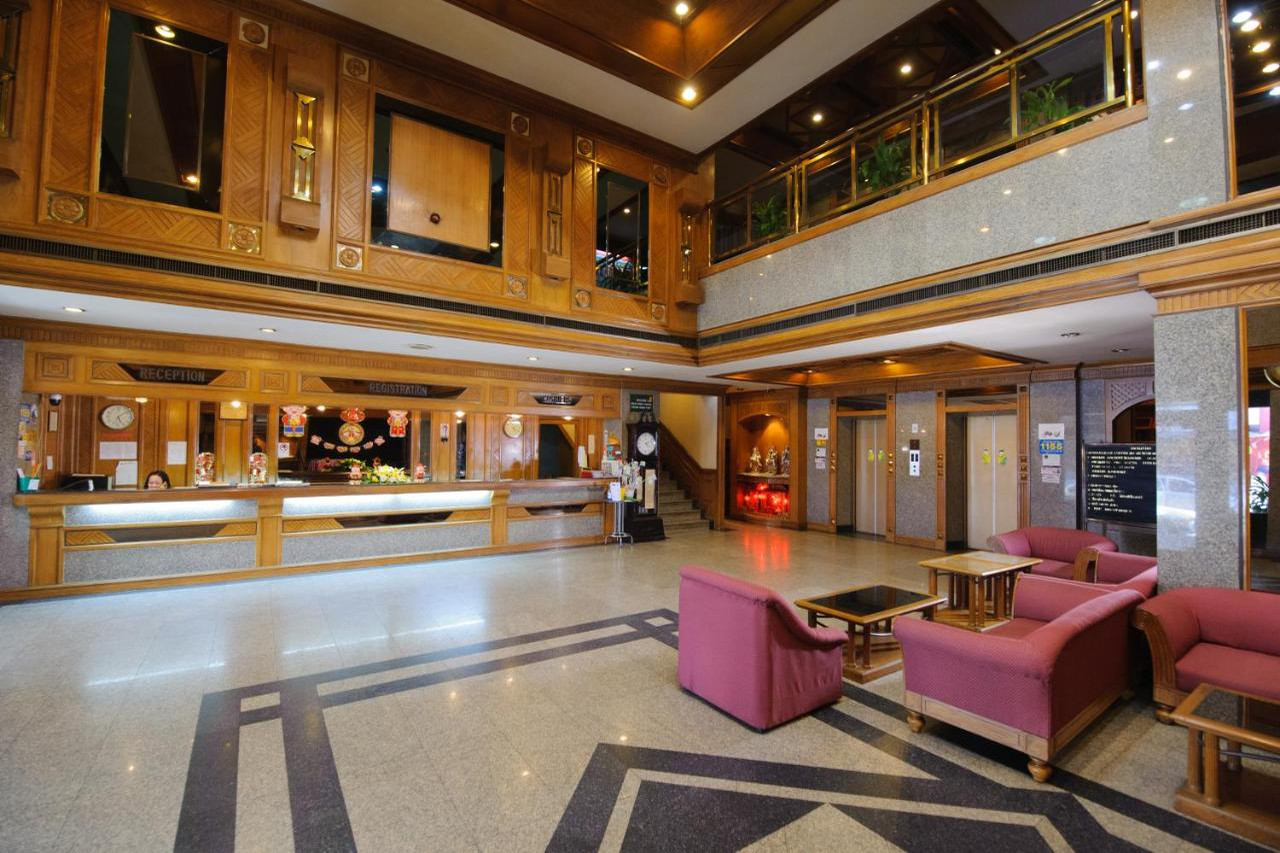ล็อบบี้ไม้สักเพดานสูงพร้อมเคาน์เตอร์ต้อนรับของ Betong Merlin Hotel