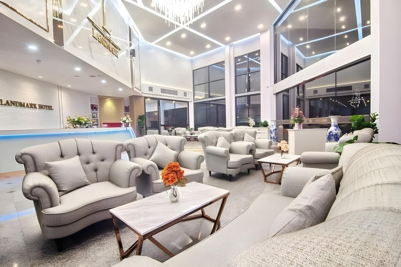 ล็อบบี้เพดานสูงพร้อมโซฟาและป้าย Landmark Hotel