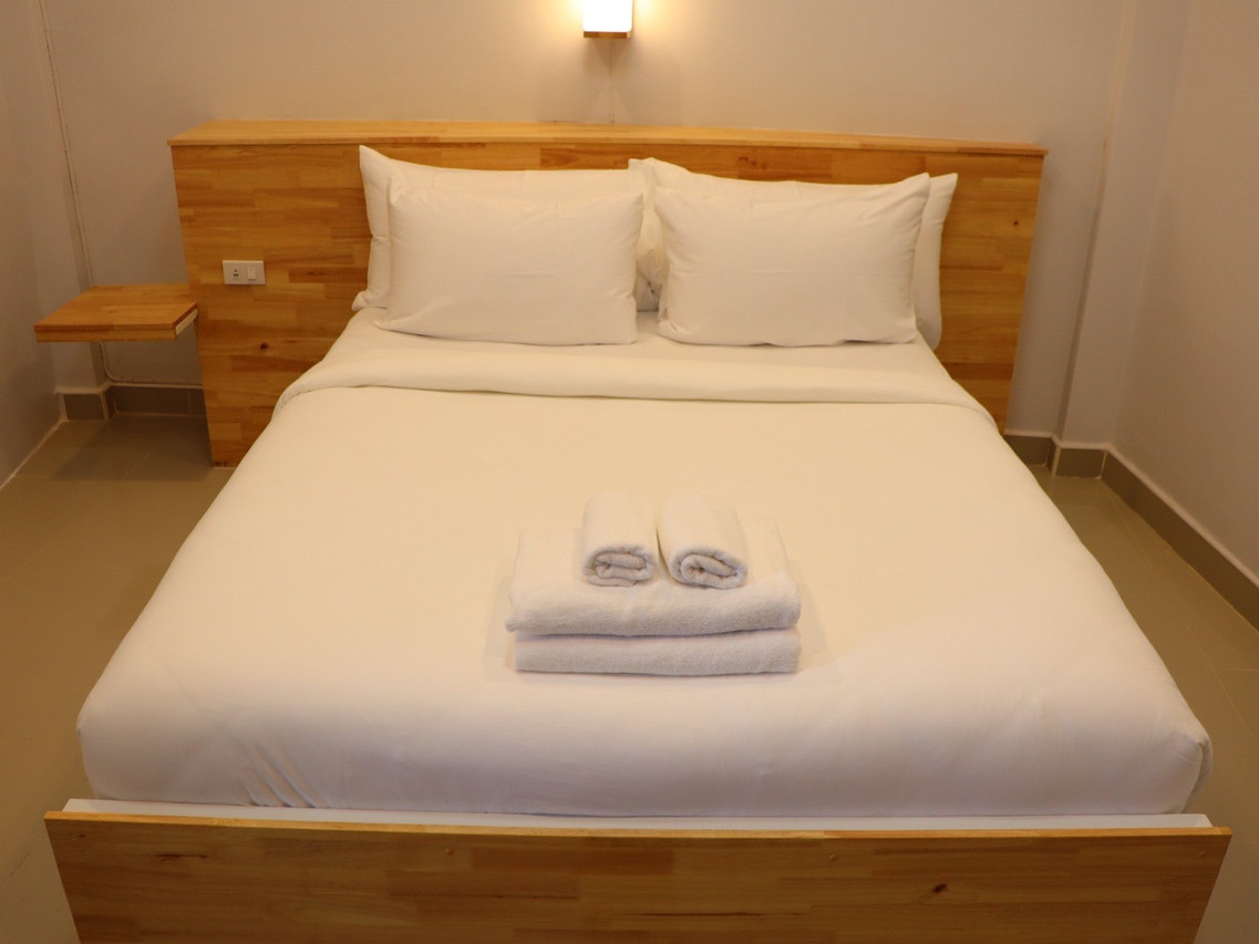 ห้องพักเตียงควีนของ Moya Boutique Hotel Betong หัวเตียงไม้ ผ้าปูขาวสะอาด