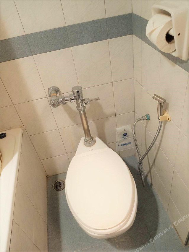 โถสุขภัณฑ์พร้อมสายฉีดชำระในห้องน้ำของโรงแรม