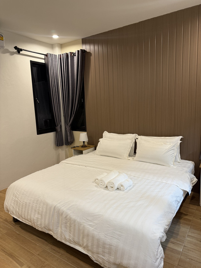 ห้อง Garden Room เตียง King ผนังไม้โทนอุ่น ม่านสีเทา บรรยากาศเงียบสบาย